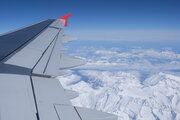 Blick aus dem Flugzeug auf scheebedeckte Alpen