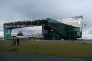 Wolken spiegeln sich in der Glasfront des Konzerthauses Harpa in Reykjavík, Island